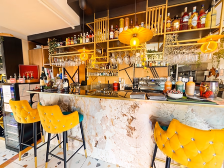 Bar du restaurant avec tabourets jaunes et cocktails